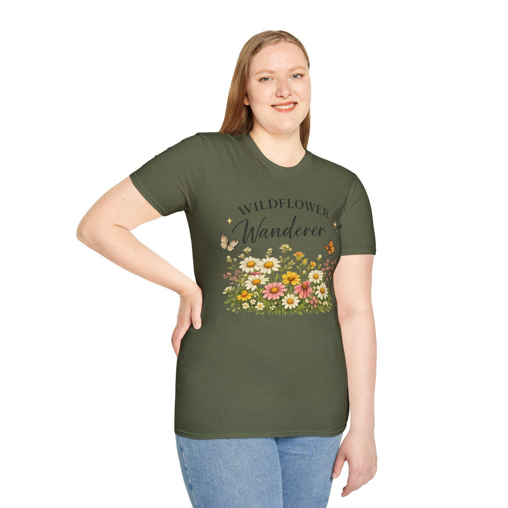 A smiling woman with long blonde hair wears a dark green t-shirt with a graphic of colorful wildflowers and butterflies, with the text "WILDFLOWER Wanderer" above.