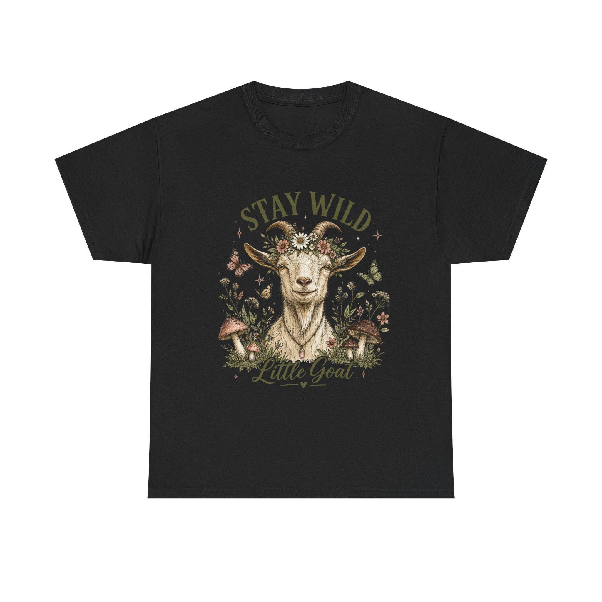 A black t-shirt with a graphic of a goat wearing a floral crown, surrounded by mushrooms and butterflies, with the text "Stay Wild Little Goat."