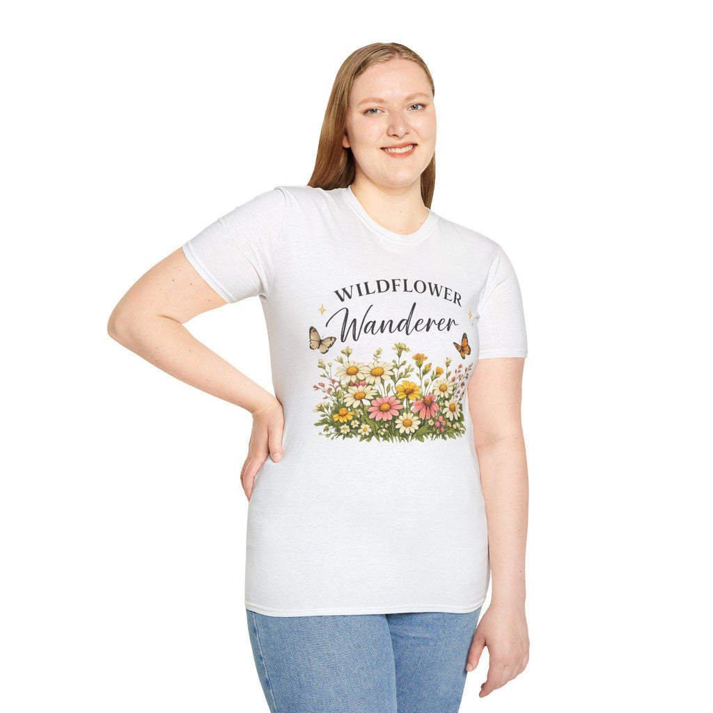 A smiling woman with long blonde hair wears a white t-shirt with a graphic of colorful wildflowers and butterflies, with the text "WILDFLOWER Wanderer" above.