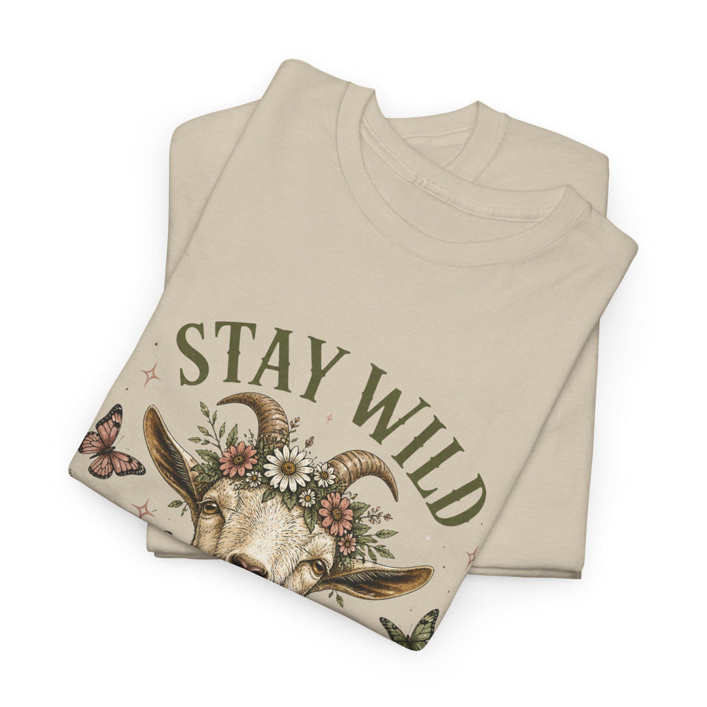 Two folded light beige t-shirts, with the top one displaying the upper half of a goat wearing a floral crown and the text "Stay Wild."