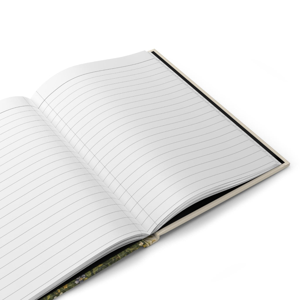 An open journal showing blank, lined pages on both sides, with a glimpse of the wildflower cover design on the left.