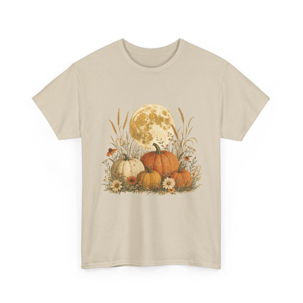 A light beige t-shirt displays a graphic of a large full moon behind a cluster of pumpkins, tall grasses, and small flowers.