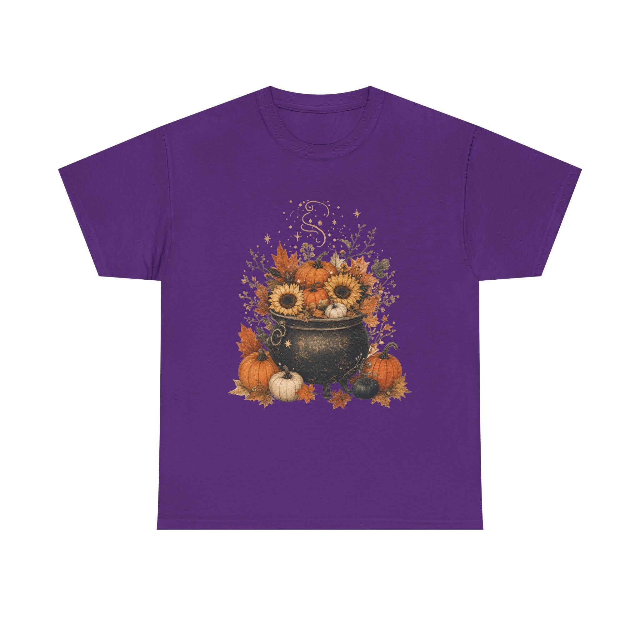 A purple short-sleeved t-shirt with a fall-themed graphic of a black cauldron filled with sunflowers, pumpkins, and autumn leaves.