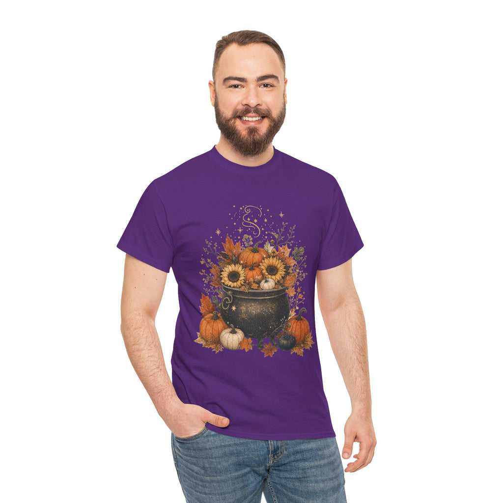 A man with a beard smiles while wearing a purple t-shirt with a graphic of a black cauldron filled with pumpkins, sunflowers, and autumn leaves.