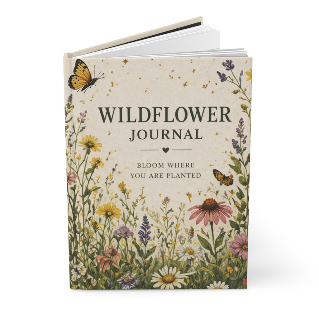 An open journal with a wildflower cover design, showing blank lined pages inside.