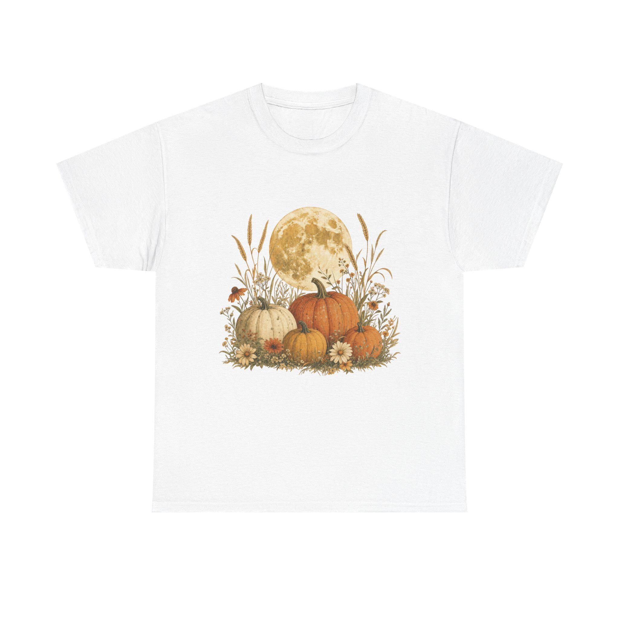 A white t-shirt with a graphic of a full moon behind a patch of pumpkins, tall grass, and flowers.