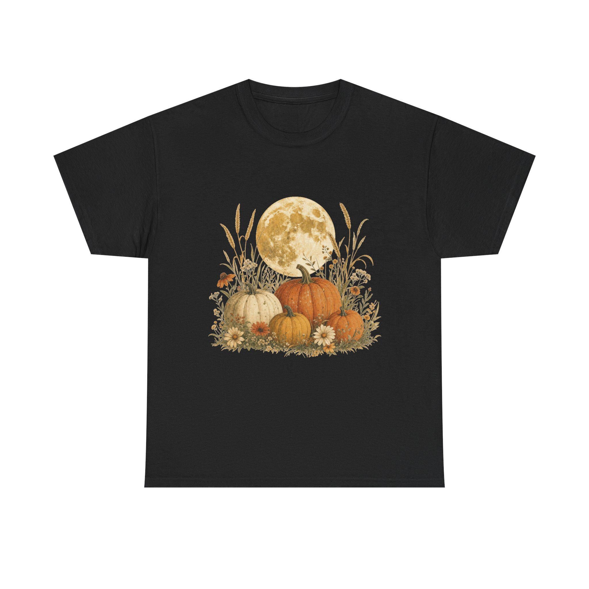 A black t-shirt with a graphic of a full moon behind a patch of pumpkins, tall grass, and flowers.