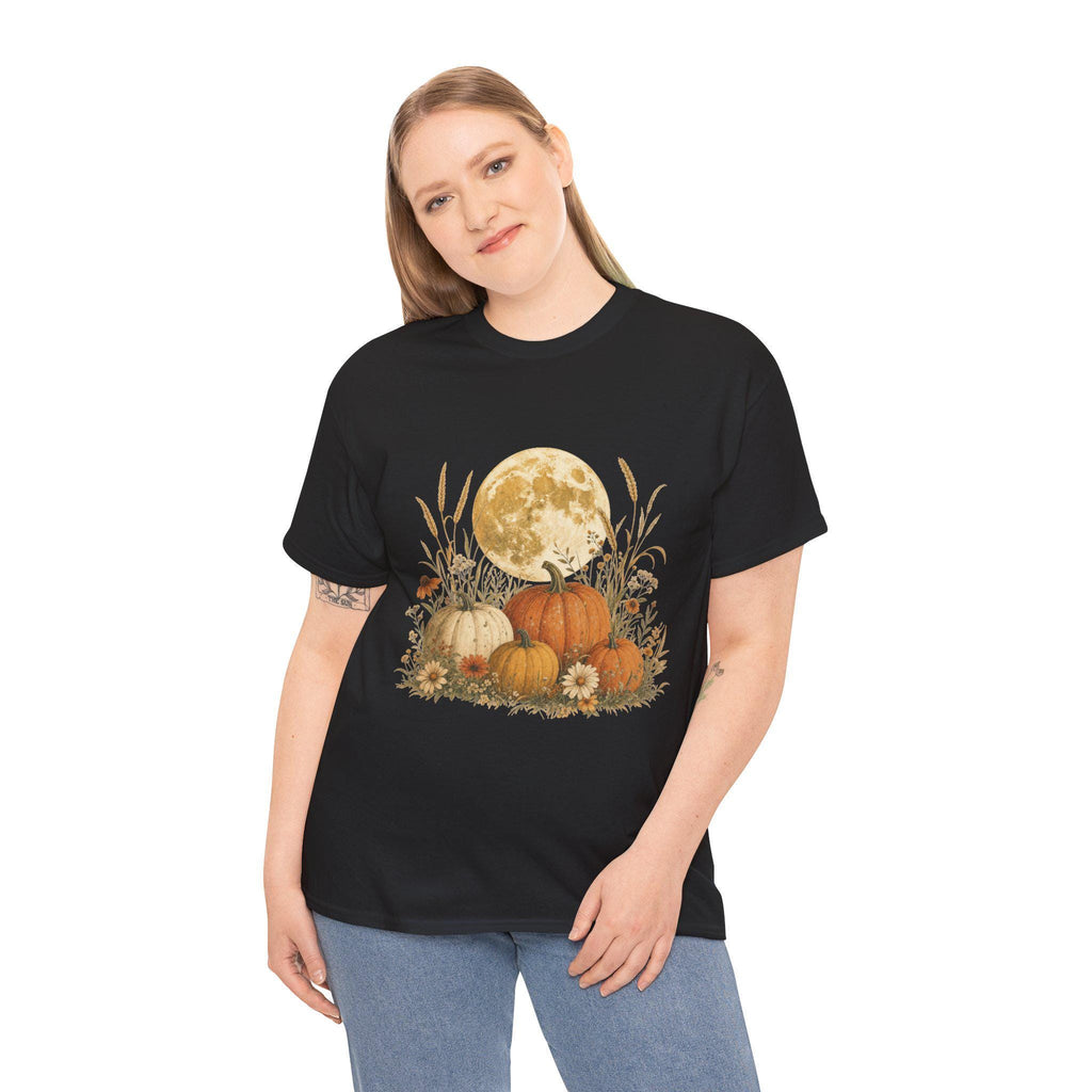 A woman with blonde hair wearing a black t-shirt with a graphic of a full moon behind a patch of pumpkins, tall grass, and flowers.