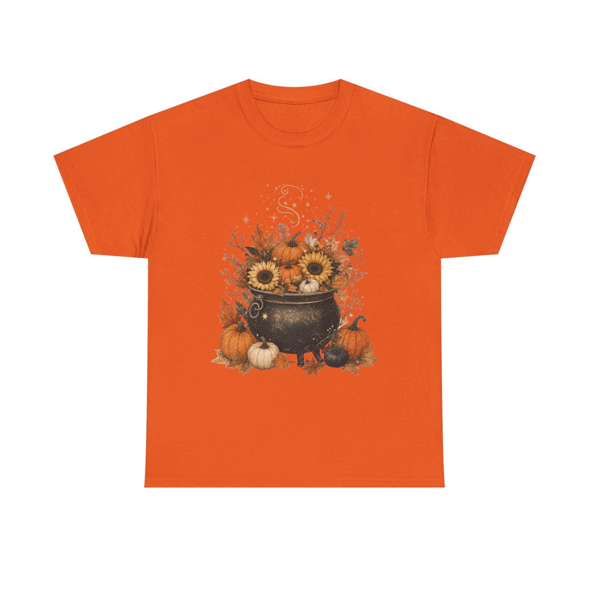 An orange short-sleeved t-shirt with a fall-themed graphic of a black cauldron filled with sunflowers, pumpkins, and autumn leaves.