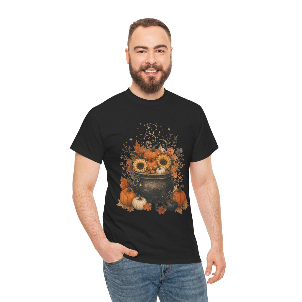 A smiling man with a beard wears a black short-sleeved t-shirt with a fall-themed graphic of a black cauldron filled with sunflowers, pumpkins, and autumn leaves.